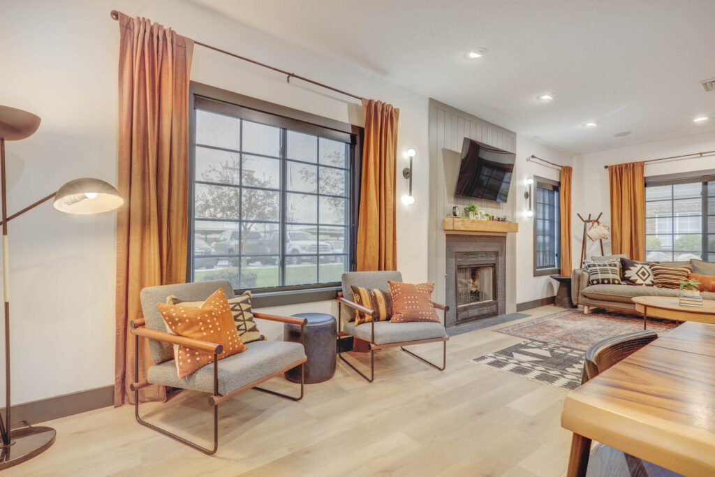 Clubhouse lounge with sofas and armchairs around a fireplace and TV